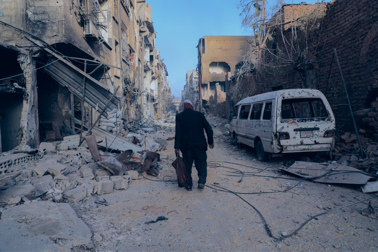 A man walks through a destroyed neighbourhood in NW Syria. Credit: A. Hammam/INSO