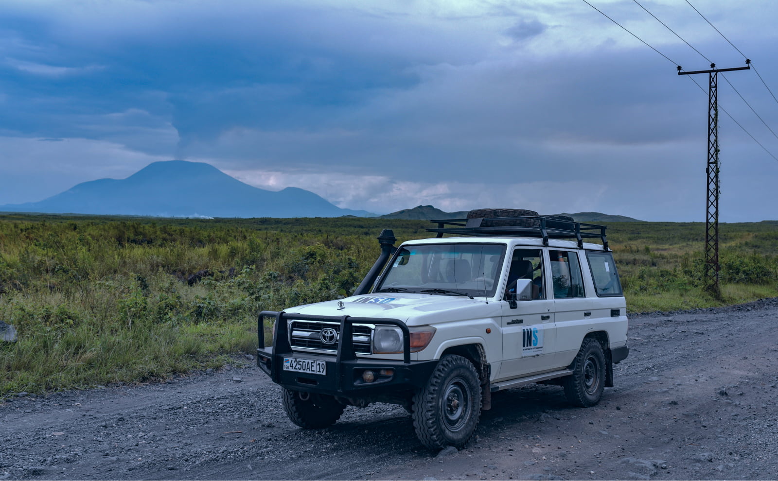 INSO's car outside of Sake, DRC with a volcano in the background. Credit: O. Acland/INSO