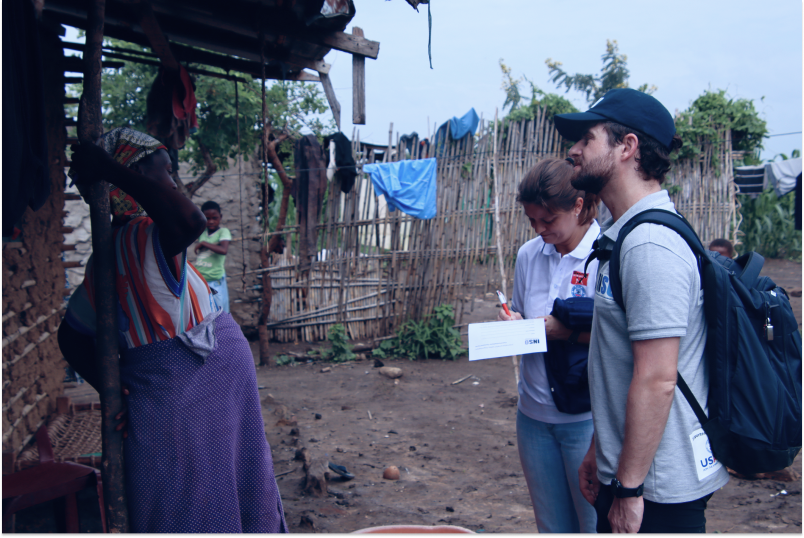 An INSO staff members talks to a woman outside her house in Metuge, Mozambique