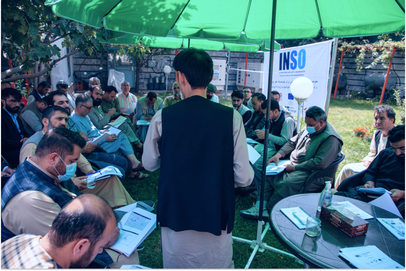 INSO staff member leads a roundtable outside.
